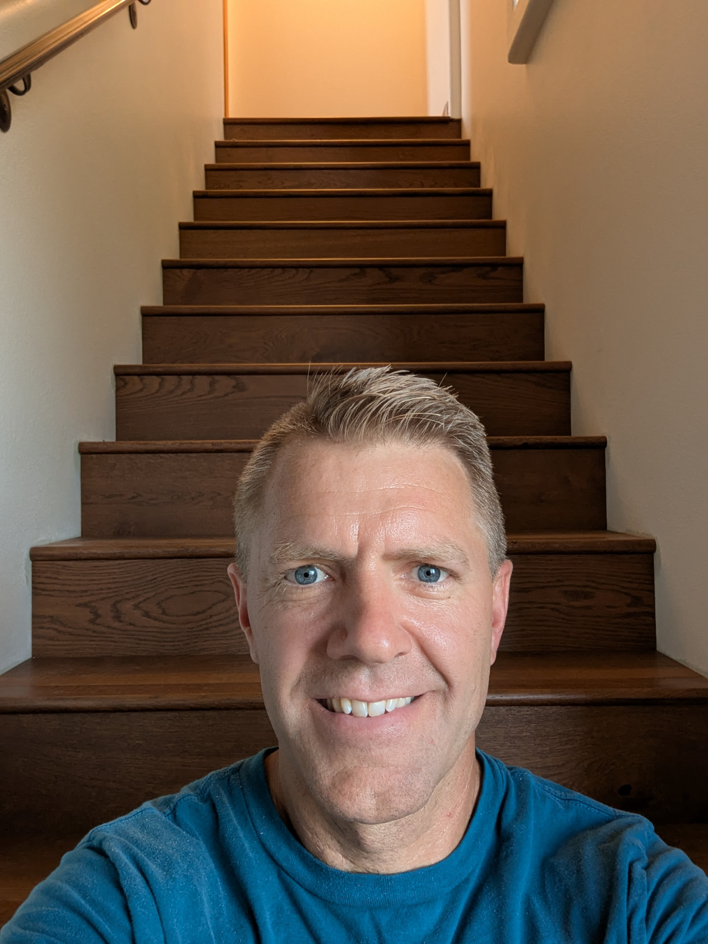 Todd Kinsey, owner of Floor & Window Covering Connection, standing on a hardwood staircase he installed